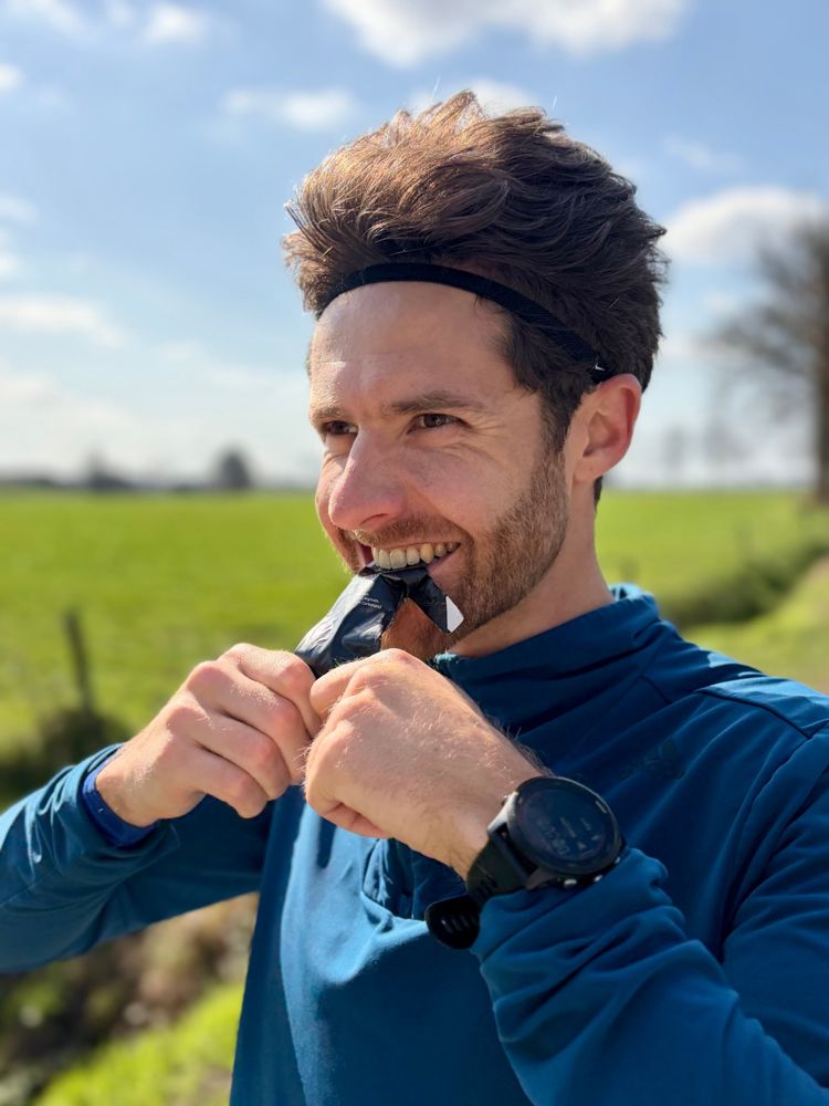 Andy opening an energy gel during a training run